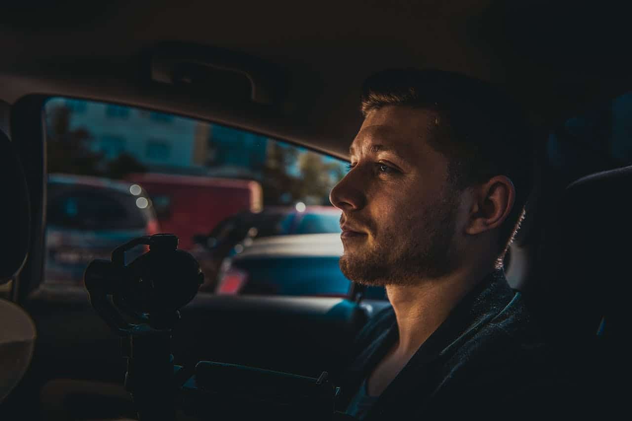 Hombre sentado en taxi sujetando una cámara