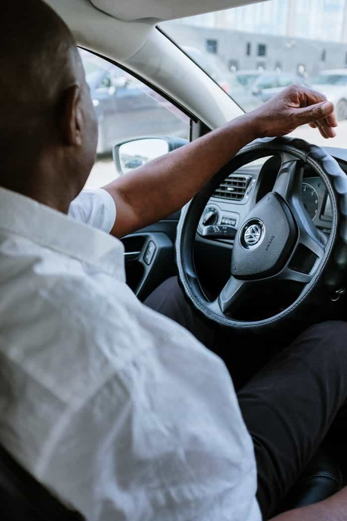 Hombre con camisa blanca conduciendo un Taxi