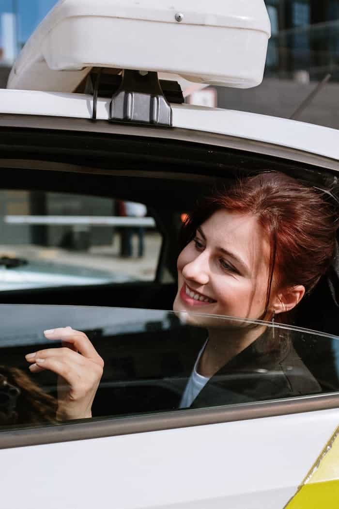 Mujer en Taxi sonriendo en la ventanilla
